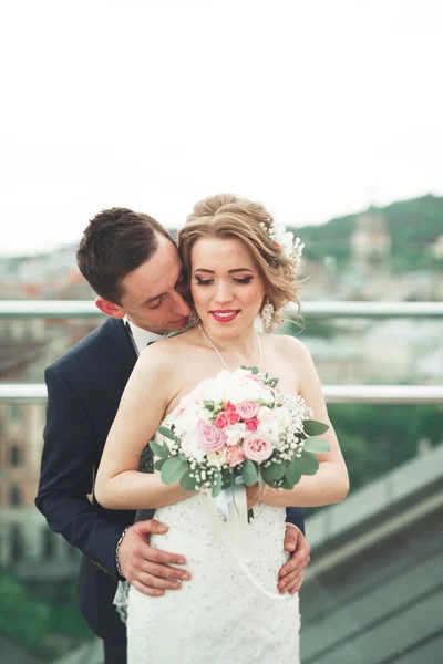 Schönes Paar, Braut und Bräutigam posiert auf Balkon mit Hintergrund der Altstadt — Stockfoto