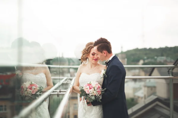 Glückliches Hochzeitspaar, Braut, Bräutigam küssen sich mit Blick auf die Altstadt — Stockfoto