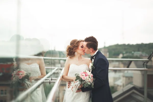 Glückliches Hochzeitspaar, Braut, Bräutigam küssen sich mit Blick auf die Altstadt — Stockfoto