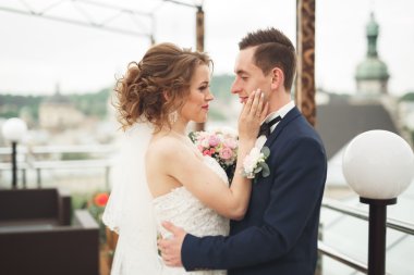 Mutlu düğün çift, Gelin, damat eski şehir manzarası ile öpüşme