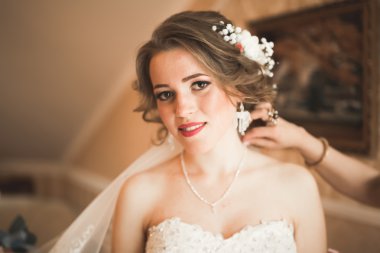 Beyaz elbiseli lüks gelin düğün törenine hazırlanırken poz veriyor.