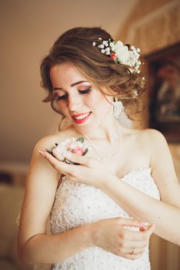 Beyaz elbiseli lüks gelin düğün törenine hazırlanırken poz veriyor.