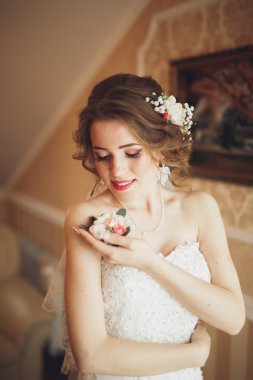 Beyaz elbiseli lüks gelin düğün törenine hazırlanırken poz veriyor.