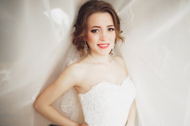 Beyaz elbiseli lüks gelin düğün törenine hazırlanırken poz veriyor.