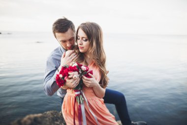 Mavi Denizi çevresinde büyük bir taş üzerinde oturan Düğün çifti