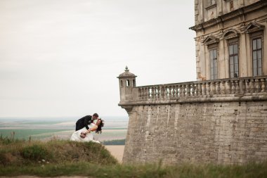 Mutlu düğün kaç sarılma ve öpüşme üzerinde arka plan eski kale