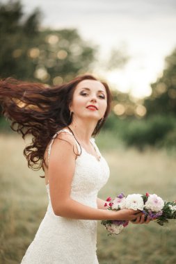 Gelin. Güzel sarışın kadın çiçek çelenk ve buket sıcak yaz gününde park