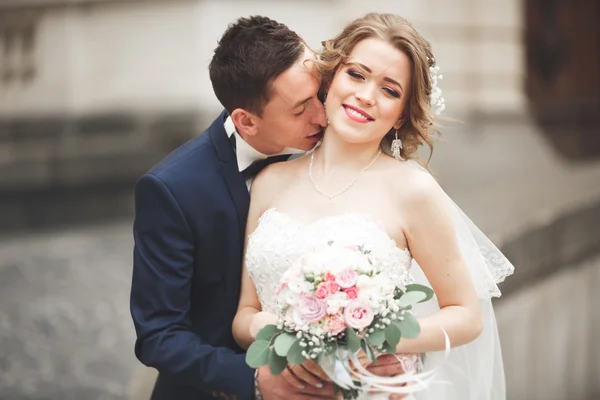 Wedding couple is standing and kissing in the streets of old city — Stock Photo, Image