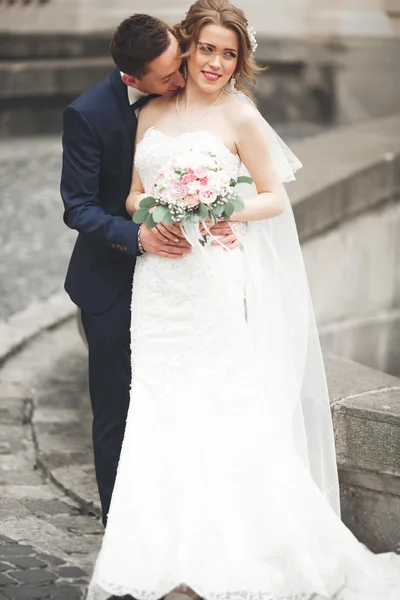 Casamento casal está de pé e beijando nas ruas da cidade velha — Fotografia de Stock