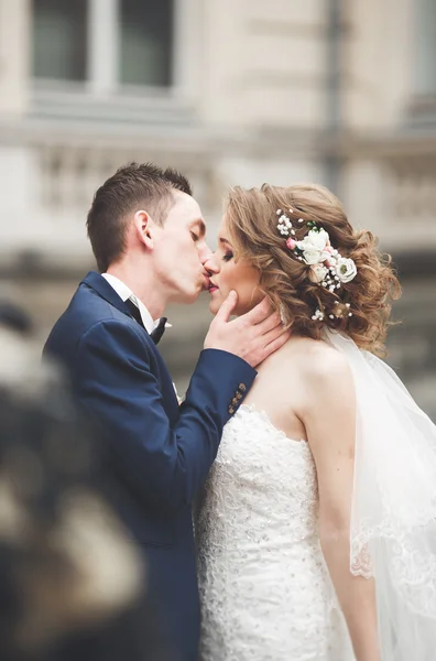 Wedding couple is standing and kissing in the streets of old city — Stock Photo, Image