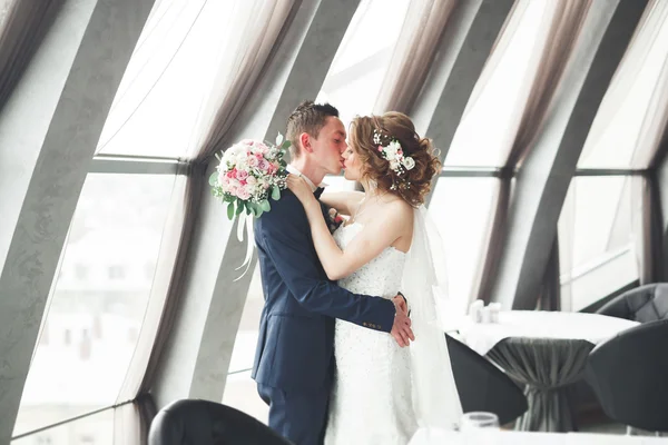 Hochzeitspaar steht und küsst sich im Hotel — Stockfoto