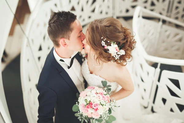 Wedding couple is standing and kissing in hotel — Stock Photo, Image