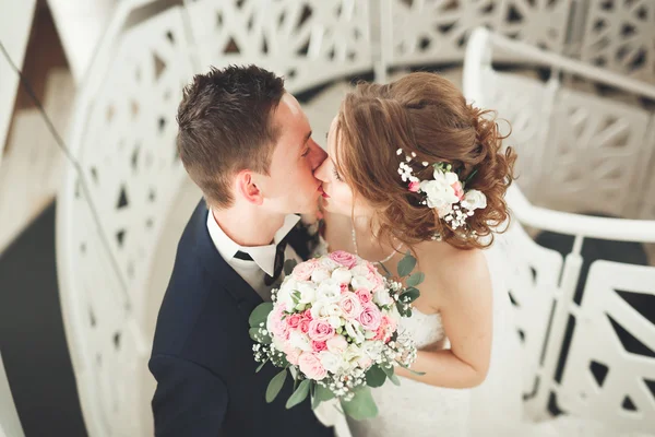 Hochzeitspaar steht und küsst sich im Hotel — Stockfoto