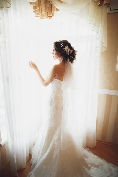 Novia de lujo en vestido blanco posando mientras se prepara para la ceremonia de boda — Foto de Stock