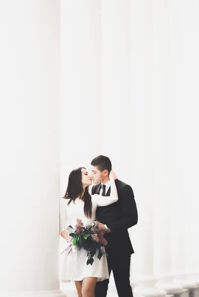 Schönes Paar, Braut und Bräutigam posiert neben großer weißer Säule — Stockfoto