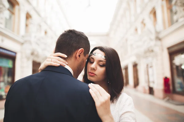 Beautiful bröllop par, bruden, brudgummen kyssas och kramas mot bakgrund av gamla byggnad — Stockfoto