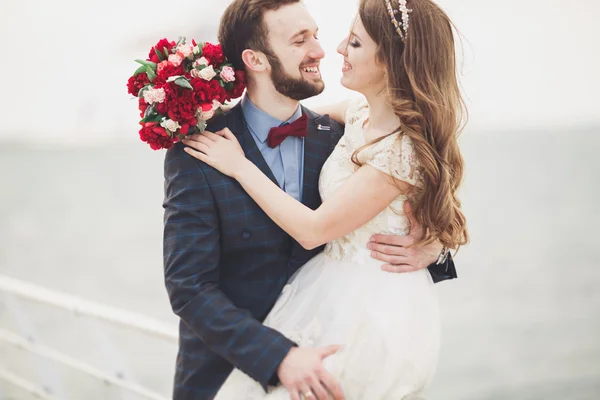 Gift bröllop par stående på en kaj över havet — Stockfoto