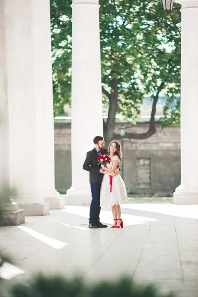 Hermosa pareja, novia y novio posando cerca de gran columna blanca —  Fotos de Stock