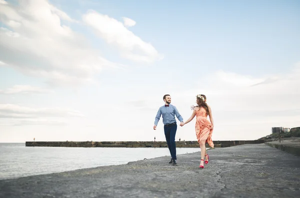 Belo casal amoroso, orgulho com vestido longo andando no cais — Fotografia de Stock