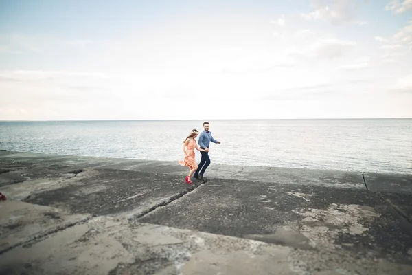 Beautiful loving couple, pride with long dress walking on pier — Stock Photo, Image