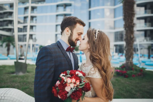 Élégant beau couple posant près du bâtiment en verre moderne — Photo