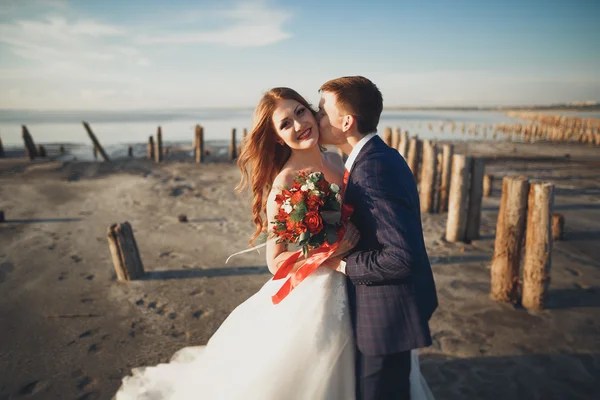 Şık, şık, mutlu bir düğün çifti, gelin, deniz ve gökyüzünün arka planında muhteşem bir damat. — Stok fotoğraf