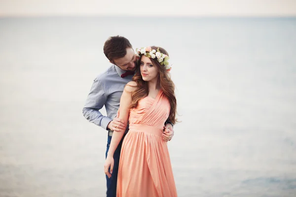 Casada pareja de boda de pie en un muelle sobre el mar — Foto de Stock