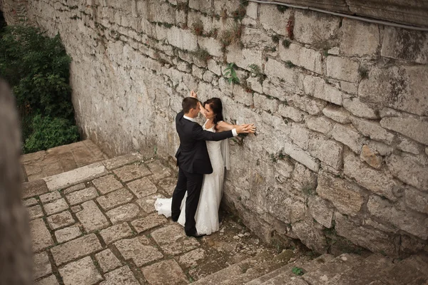 Ευτυχισμένος γάμος ζευγάρι αγκάλιασμα και το φίλημα στο παλιό κάστρο φόντο — Φωτογραφία Αρχείου