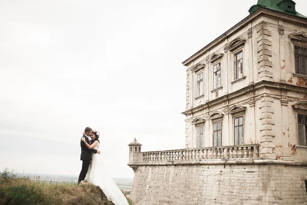 Krásný romantický svatební pár novomanželé objímání v blízkosti starého hradu — Stock fotografie