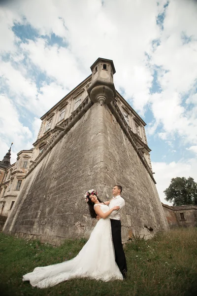 Feliz boda pareja abrazos y besos en el fondo viejo castillo — Foto de Stock