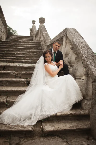 Szczęśliwy wesele para przytulanie i całowanie na tle starego zamku — Zdjęcie stockowe