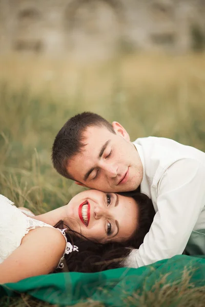 Ευτυχισμένο γάμο ζευγάρι ξαπλωμένο σε πράσινο γρασίδι κατά τη διάρκεια του καλοκαιριού — Φωτογραφία Αρχείου