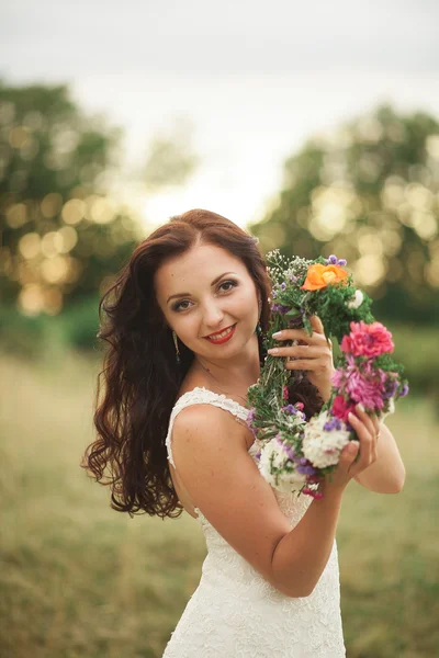 Pengantin. Wanita cantik berambut pirang di taman dengan karangan bunga dan karangan bunga pada hari musim panas yang hangat — Stok Foto