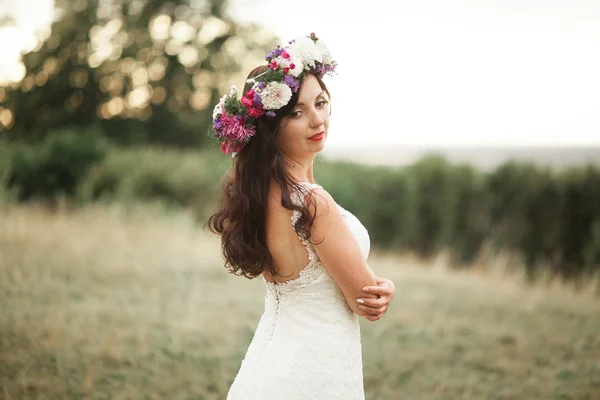 Noiva. Mulher loira jovem bonita no parque com coroa de flores e buquê em um dia quente de verão — Fotografia de Stock