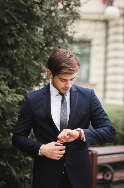 Hombre de negocios confiado mirando su reloj de pulsera en traje —  Fotos de Stock