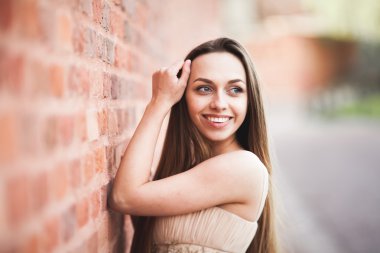 Uzun saç ve elbise mükemmel şekli tabaklanmış vücut possing duvarının yakınında güzel seksi kız