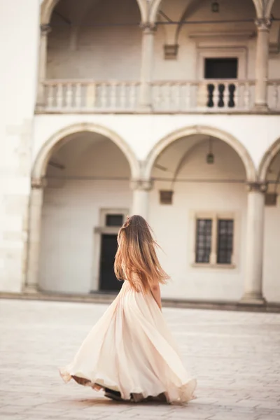 Belle fille, modèle avec les cheveux longs posant dans le vieux château près des colonnes. Vavel de Cracovie — Photo