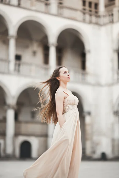 Güzel kız modeli sütunları yakınındaki eski kale poz uzun saçlı. Krakow Vavel — Stok fotoğraf