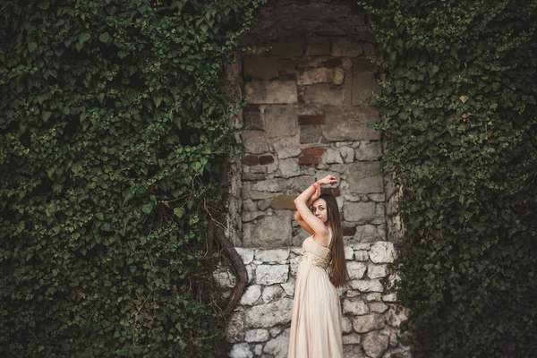 Beautiful girl, model near the wall of leaves and bushes in park — Stock Photo, Image