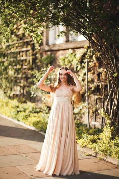 Aantrekkelijke jonge vrouw met lange jurk genieten van haar tijd buiten in park zonsondergang achtergrond — Stockfoto