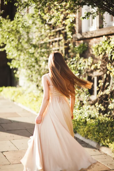 Aantrekkelijke jonge vrouw met lange jurk genieten van haar tijd buiten in park zonsondergang achtergrond — Stockfoto