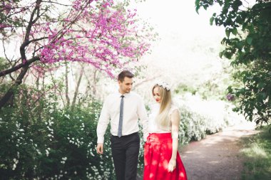 Şık güzel mutlu düğün çift öpüşme ve Botanik Bahçesi içinde kucaklayan