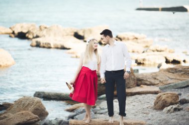 Deniz, mavi gökyüzü yakınındaki taş poz romantik sevgi dolu Çift