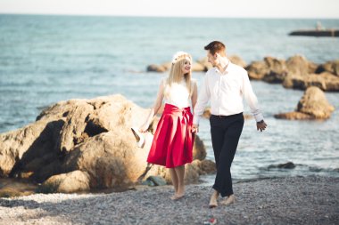 Deniz, mavi gökyüzü yakınındaki taş poz romantik sevgi dolu Çift