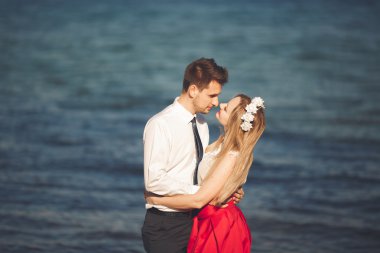 Genç mutlu çift holding birbirlerini etrafında gülümseyen Sahilde yürüyüş. Aşk hikayesi