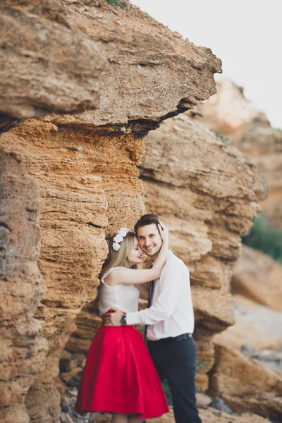 Romantische verliefde paar wandelen op het strand met rotsen en stenen — Stockfoto