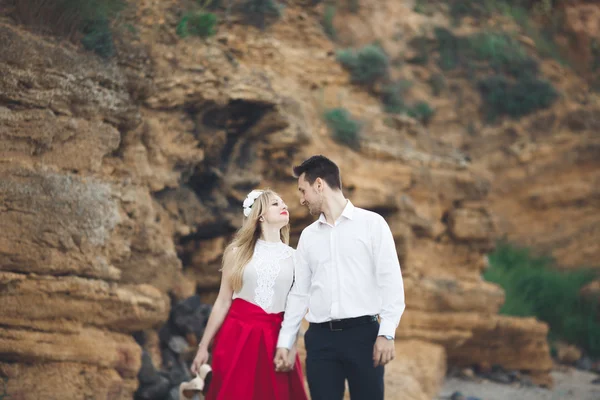 Romantyczna para kochających spacery na plaży z skał i kamieni — Zdjęcie stockowe