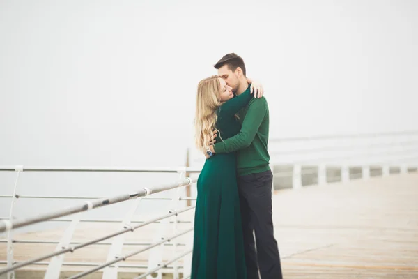 Preciosa pareja besándose y abrazándose en un muelle de mar —  Fotos de Stock