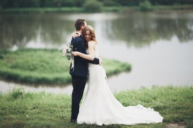 Romantik düğün çift karı güzel göl kenarında poz,