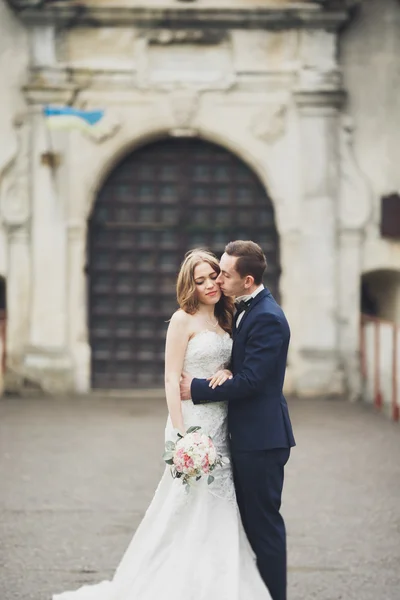 Feliz casamento casal abraçando e sorrindo uns aos outros no fundo velho castelo — Fotografia de Stock